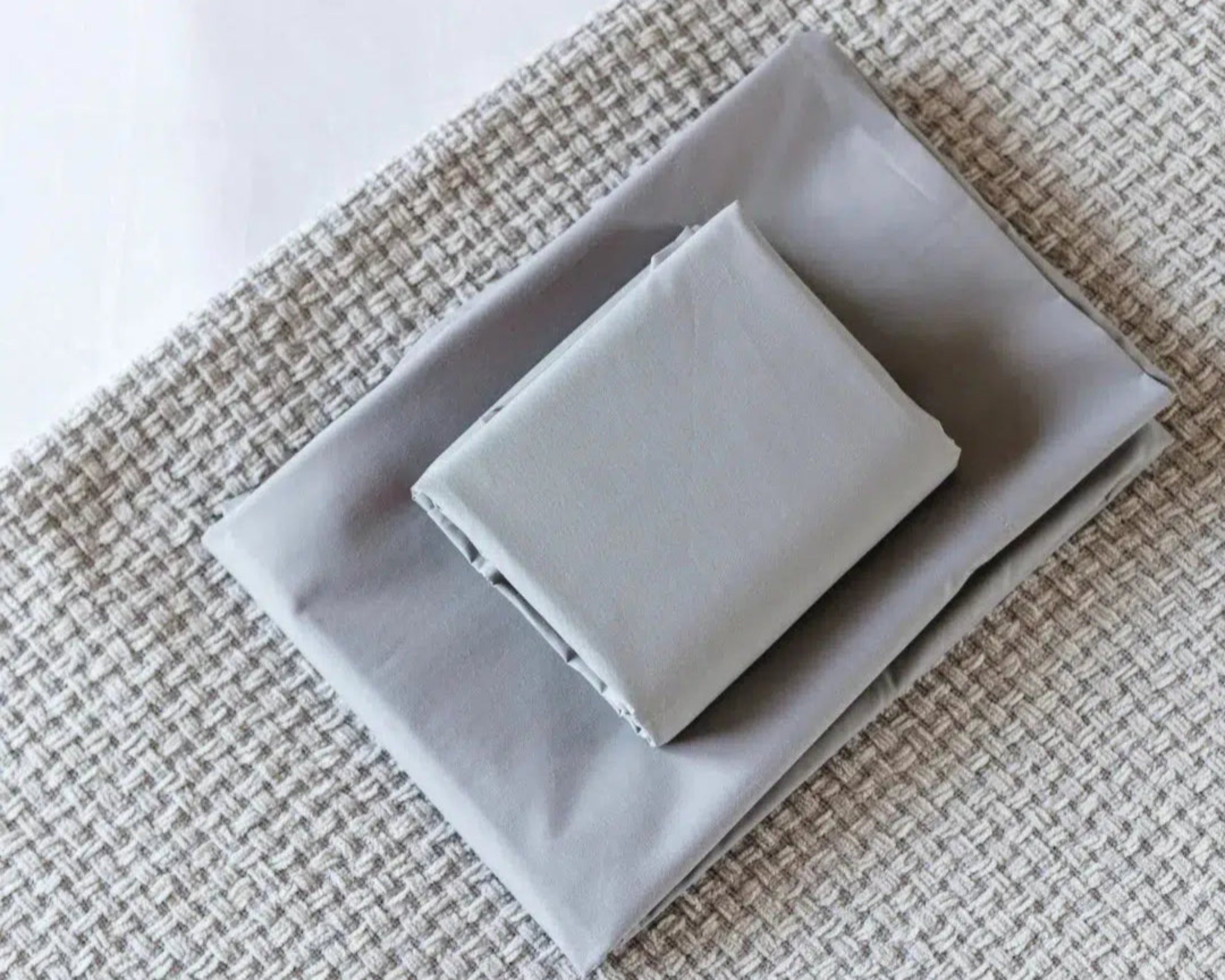 Folded grey Percale Sheet Set from the Haven Clean Sleep Bundle, featuring cool, breathable 100% cotton fabric.