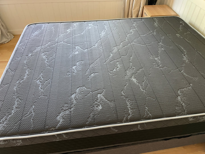 Close-up view of the Haven HD Hybrid mattress surface, showcasing its intricate black and gray textured design. The mattress, designed for plus-size sleepers, features contouring Talalay latex and NaturFoam layers for firm and extra-firm support. The high-density surface offers a detailed look at the craftsmanship and quality materials used for optimal comfort and durability.