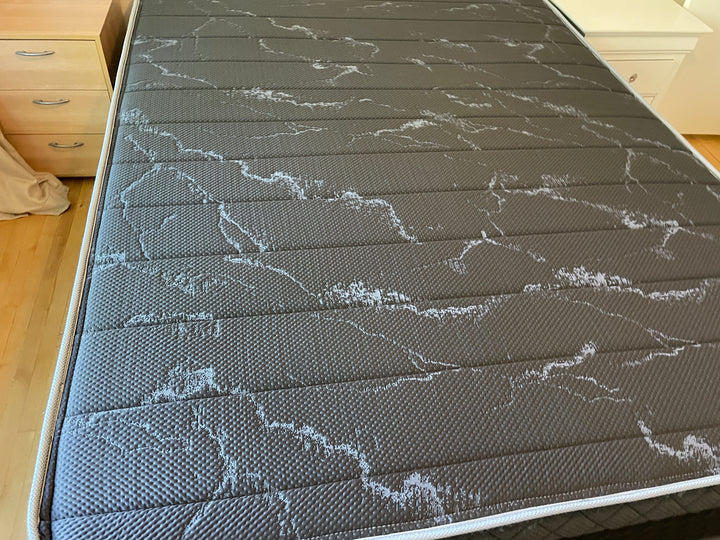 Top view of the Haven HD Hybrid mattress, showcasing the black and gray textured surface with intricate patterns. Designed for plus-size sleepers, this mattress features Talalay latex and 7-zone HD coils for firm and extra-firm support. The image highlights the premium materials and detailed craftsmanship, offering both comfort and durability.