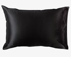 Black satin pillowcase from the Dream Satin Sleep Set, featuring a smooth and glossy finish that is a sustainable and cruelty-free alternative to traditional silk, designed to protect hair and provide a luxurious sleep experience.