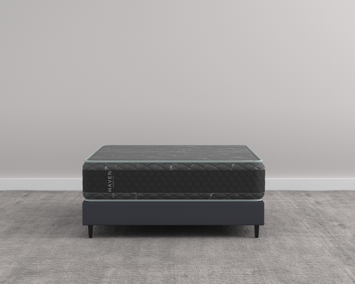 Side view of the Haven HD Hybrid mattress, showcasing its durable black and gray design on a modern bed frame. This Canadian-made mattress is tailored for plus-size sleepers, featuring 7-zone HD coils and Talalay latex for firm and extra-firm support. The image highlights the mattress’s robust construction and elegant finish, perfect for providing enhanced comfort and longevity.