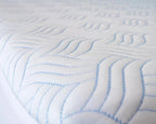 Side View of Haven Cool Ice Mattress Protector on Bed - Breathable, Waterproof Fabric with Wavy Stitching