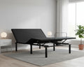 Black adjustable bed in a room with a window, plant, and nightstand.
