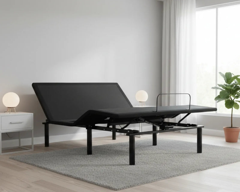 Black adjustable bed in a room with a window, plant, and nightstand.