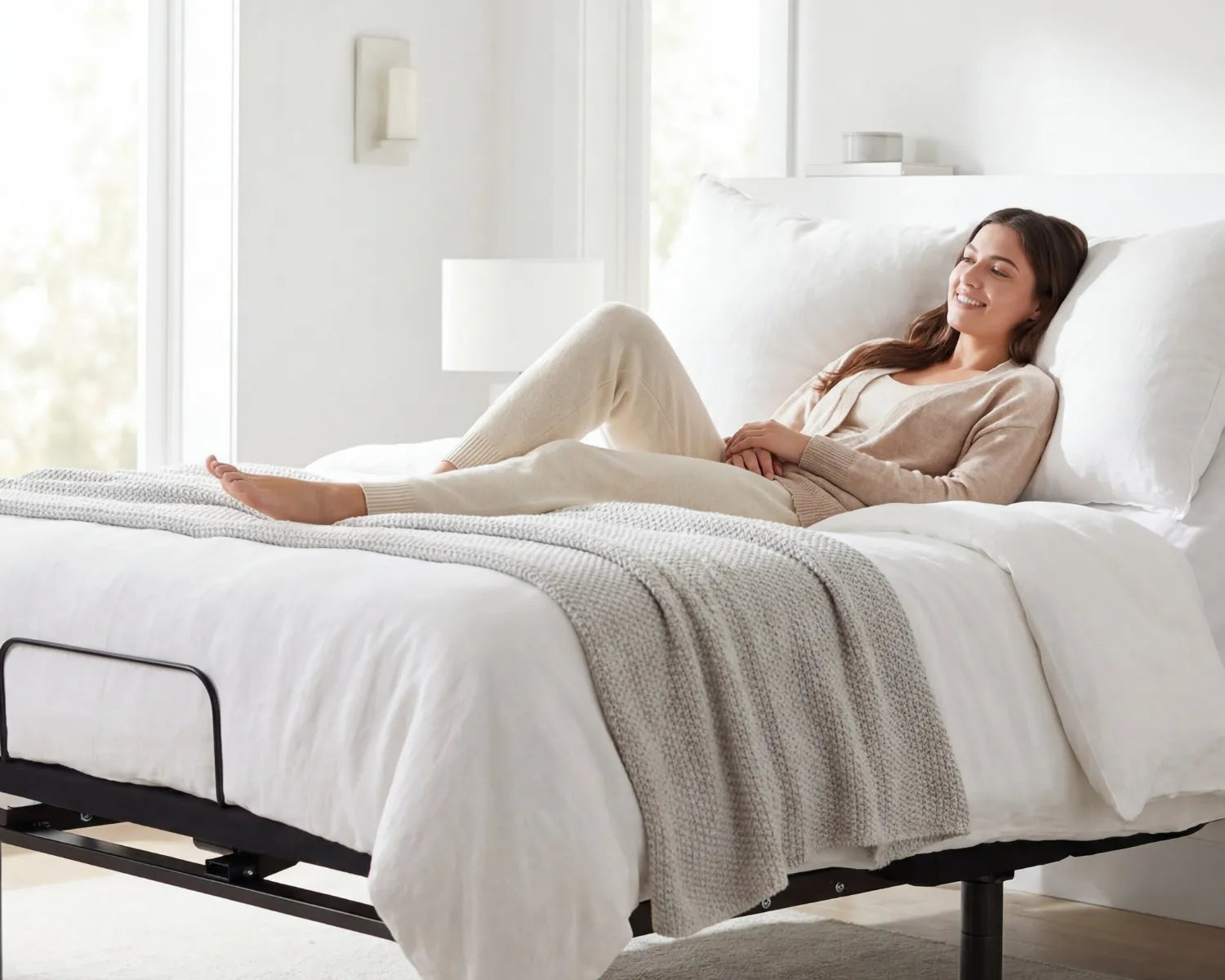 Woman lying on a bed in a bright, minimalistic bedroom