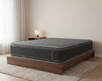 Gray mattress on a wooden bed frame in a room with beige walls and a rug.