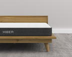 Hiber mattress on a wooden bed frame with a plain background