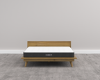 Mattress on a wooden bed frame with 'Hiber' branding against a plain wall.