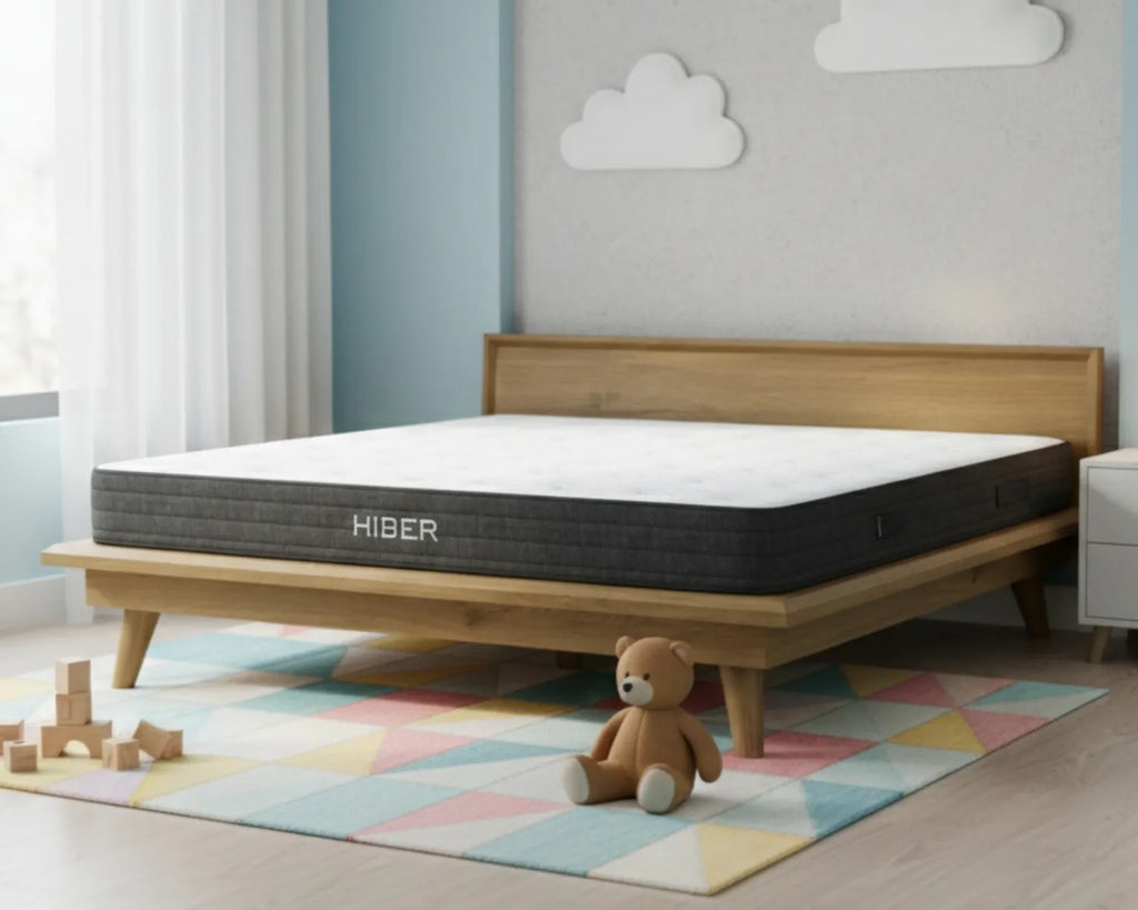 Hiber mattress on a wooden bed frame in a child's room with toys and a teddy bear.
