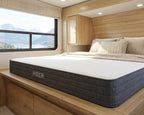 Hiber mattress in a bedroom with wooden walls and a window view of mountains.