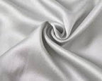 Close-up of smooth white satin fabric from the Dream Satin Sleep Set, showcasing its glossy and luxurious texture, a sustainable and cruelty-free alternative to traditional silk, designed for a comfortable and rejuvenating sleep experience.