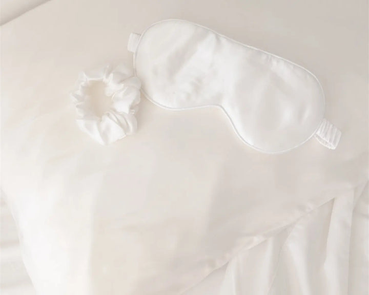 White satin eye mask on a white background