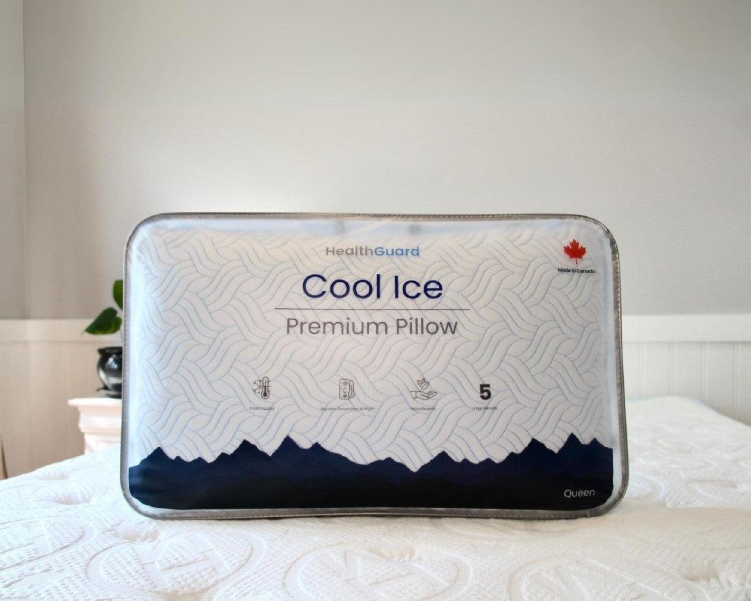 Haven Cool Ice Premium Pillow in its original packaging, featuring a cooling wave pattern design, HealthGuard branding, and a Canadian maple leaf emblem, displayed on a bed with a quilted mattress.