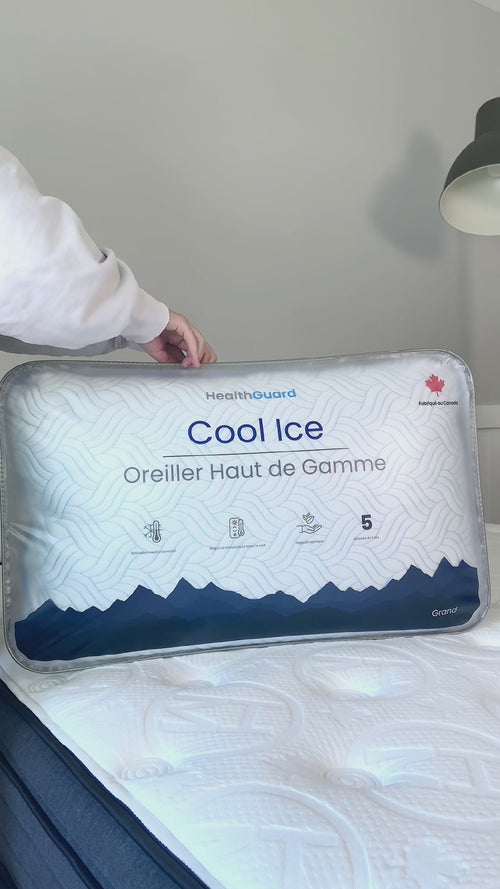 Person unboxing the Haven Cool Ice Adjustable Fill Pillow, showcasing the product's packaging with 'Cool Ice' branding and blue mountain design, alongside the pillow's cooling wave pattern on a bed.