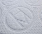 A closeup shot of an H and M letter encapsulated by a circle embroidered on a mattress.