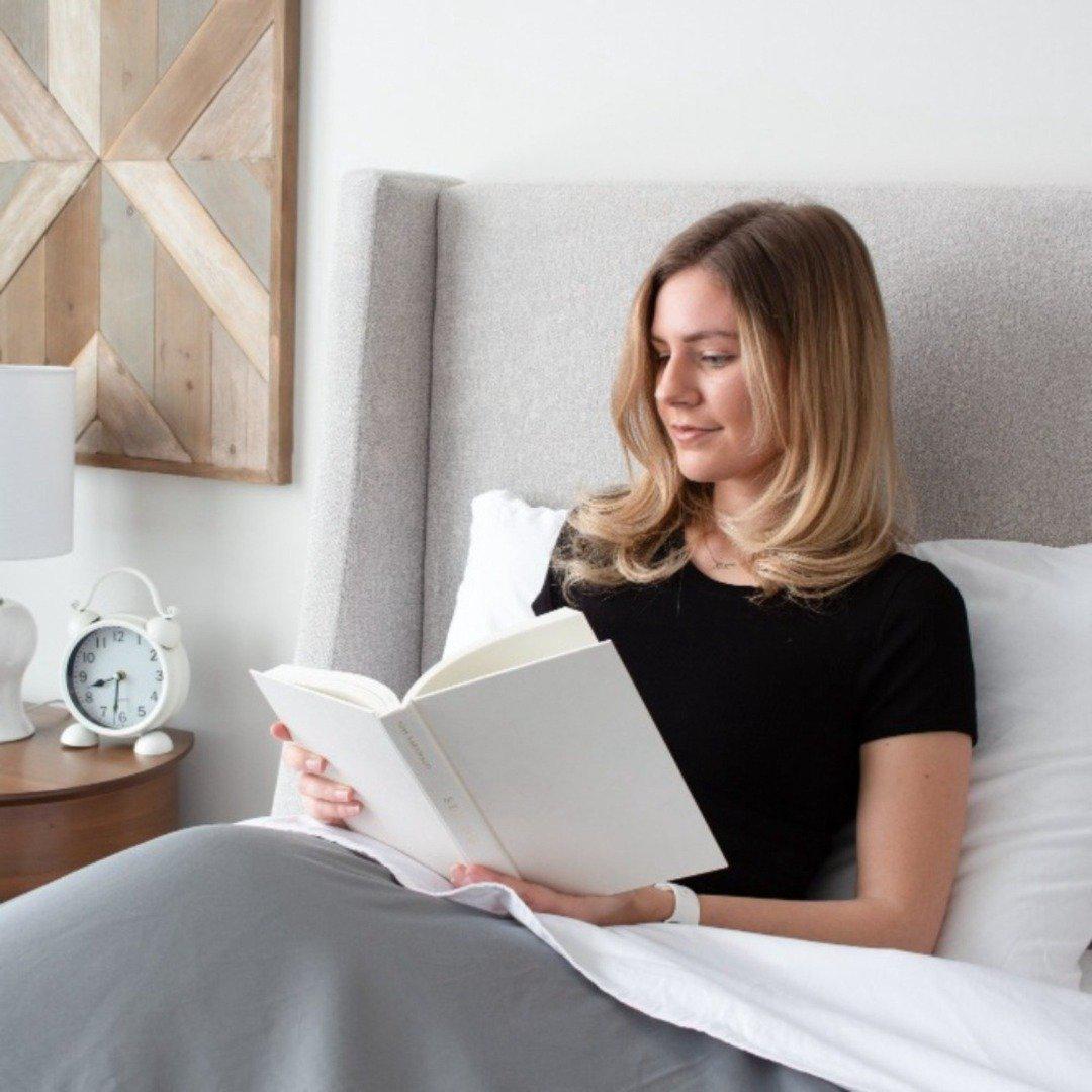 femme blonde assise lisant un livre dans son ensemble de draps bedface